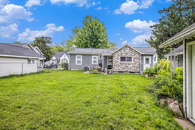 512 Clark St, Big Rapids, MI 49307 - rear view of property featuring a patio area, roof with shingles, and stone siding