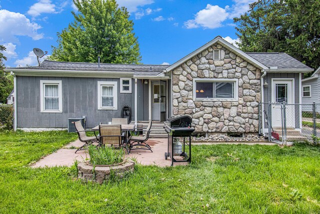 512 Clark St, Big Rapids, MI 49307 - back of house featuring stone siding, a patio area, and roof with shingles