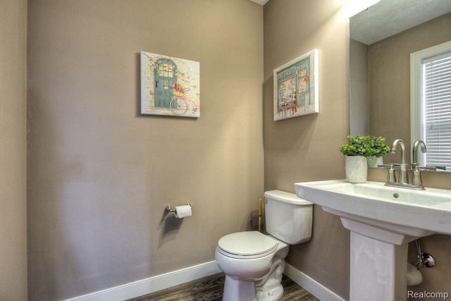 2099 Stillwater Dr, Davison, MI 48423 - half bath with toilet, baseboards, wood finished floors, and a sink