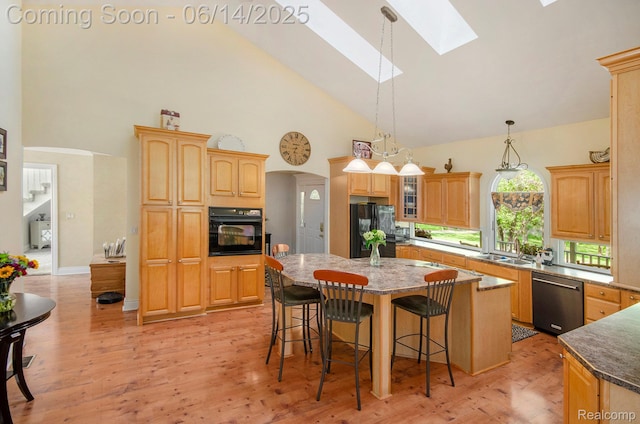 61995 Mount Vernon Rd, Washington, MI 48094 - kitchen with black appliances, a skylight, a center island, a breakfast bar, and high vaulted ceiling