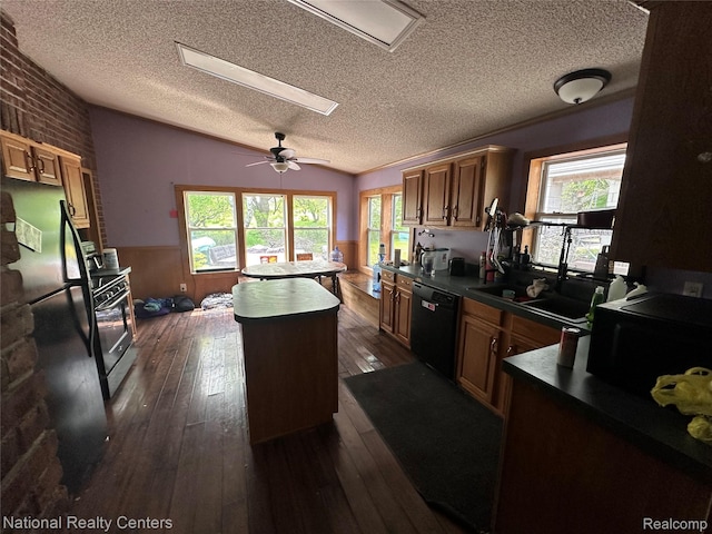 5150 Lafave Rd, Black River, MI 48721 - kitchen with black appliances, a center island, dark wood-type flooring, a textured ceiling, and dark countertops