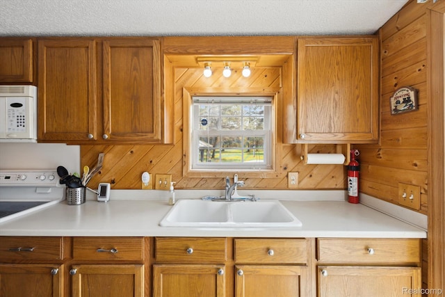 2536 Meridian Rd, Lewiston, MI 49756 - kitchen with white appliances, light countertops, wooden walls, and brown cabinets