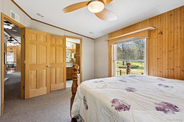 2536 Meridian Rd, Lewiston, MI 49756 - bedroom with carpet flooring, a textured ceiling, vaulted ceiling, crown molding, and wood walls