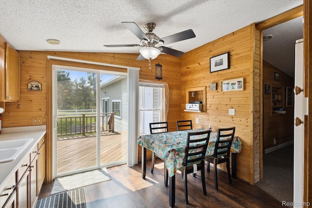 2536 Meridian Rd, Lewiston, MI 49756 - dining space with wood walls, a textured ceiling, ceiling fan, wood finished floors, and vaulted ceiling