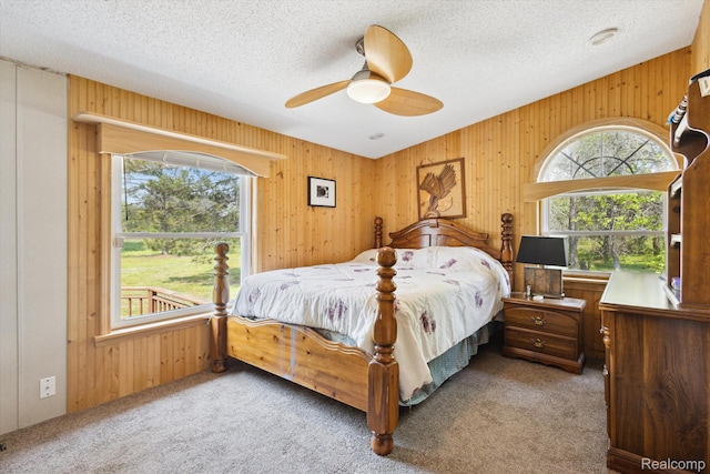 2536 Meridian Rd, Lewiston, MI 49756 - carpeted bedroom featuring wooden walls, a textured ceiling, and a ceiling fan