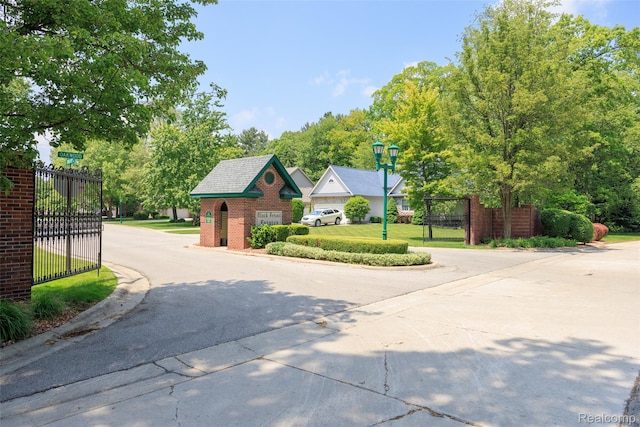 3409 Ancient Dr, Port Huron, MI 48060 - view of asphalt road with street lights, curbs, and a gate