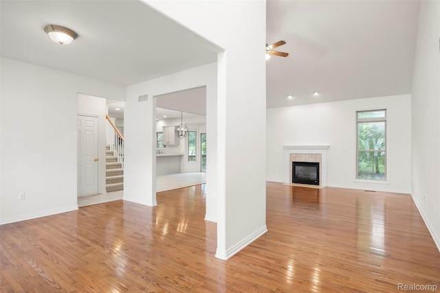 3409 Ancient Dr, Port Huron, MI 48060 - unfurnished living room featuring stairway, light wood finished floors, a fireplace, and a ceiling fan