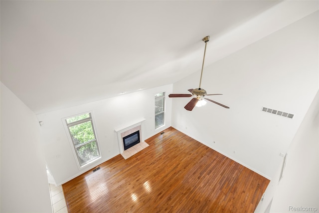 3409 Ancient Dr, Port Huron, MI 48060 - unfurnished living room with a tile fireplace, vaulted ceiling, wood-type flooring, and a ceiling fan