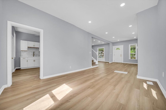 408 Mount Vernon St, Detroit, MI 48202 - unfurnished living room with light wood finished floors, stairway, a sink, recessed lighting, and baseboards
