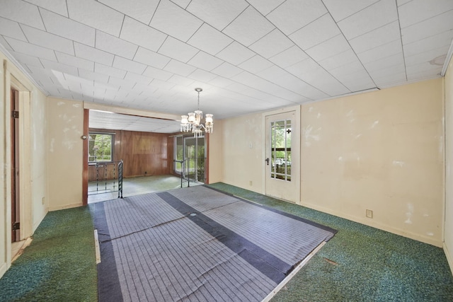 538 S Jackson St, Hanover, MI 49241 - spare room with carpet, a chandelier, and wooden walls
