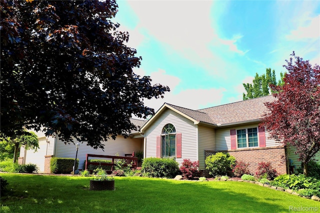 1149 Highview Dr, Lapeer, MI 48446 - view of front of house featuring brick siding, a front yard, and roof with shingles