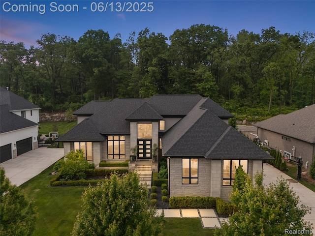 212 Enclave Ct, Rochester Hills, MI 48306 - contemporary house featuring a shingled roof, concrete driveway, stone siding, and a lawn