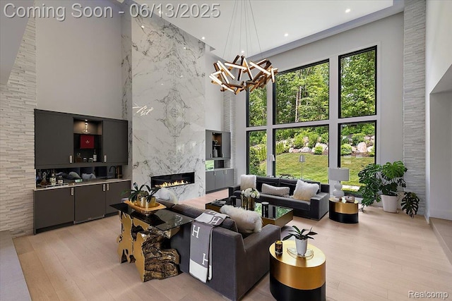 212 Enclave Ct, Rochester Hills, MI 48306 - living room with a high ceiling, a high end fireplace, a chandelier, recessed lighting, and light wood-style floors