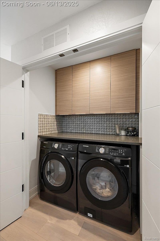 212 Enclave Ct, Rochester Hills, MI 48306 - laundry area with washer and clothes dryer, light wood finished floors, and cabinet space