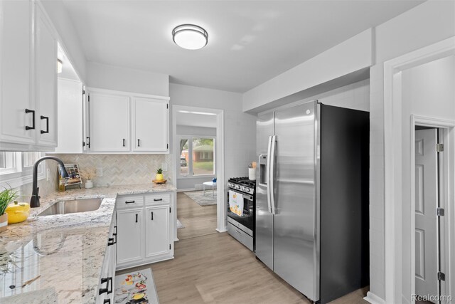 30112 Matthew St, Westland, MI 48186 - kitchen featuring appliances with stainless steel finishes, a sink, white cabinetry, backsplash, and light stone counters