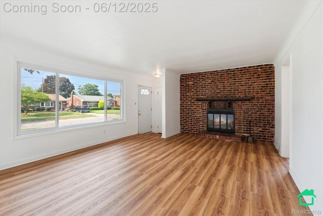 32703 Anita Dr, Westland, MI 48185 - unfurnished living room with light wood-type flooring and a fireplace