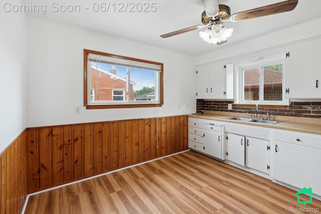 32703 Anita Dr, Westland, MI 48185 - kitchen with wainscoting, wood walls, light wood finished floors, light countertops, and white cabinets