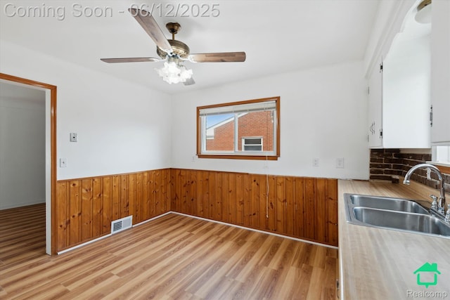 32703 Anita Dr, Westland, MI 48185 - unfurnished dining area with a wainscoted wall, light wood-type flooring, wood walls, and ceiling fan