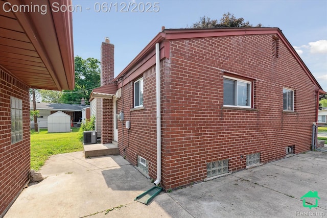32703 Anita Dr, Westland, MI 48185 - view of property exterior with a patio area, brick siding, a chimney, and a shed