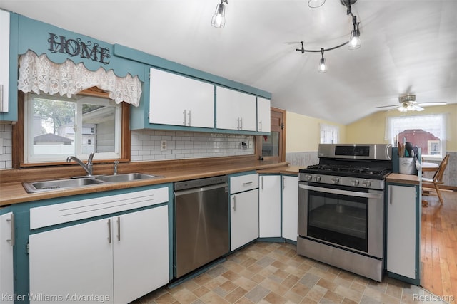 2931 4th St, Trenton, MI 48183 - kitchen featuring appliances with stainless steel finishes, white cabinets, healthy amount of natural light, and vaulted ceiling