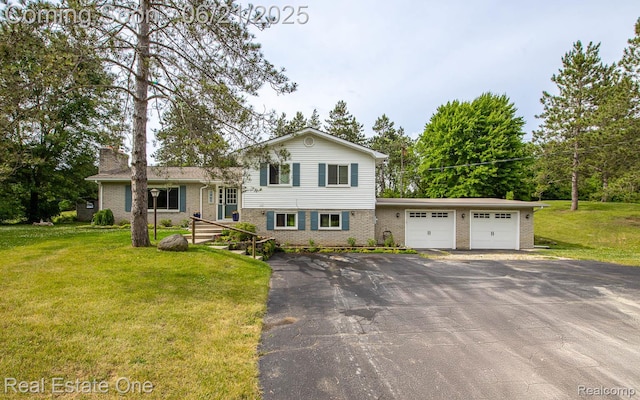 1400 W Predmore Rd, Oakland, MI 48363 - split level home featuring brick siding, a front yard, an attached garage, and asphalt driveway