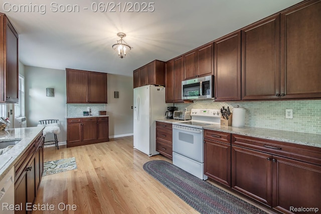 1400 W Predmore Rd, Oakland, MI 48363 - kitchen with white appliances, decorative backsplash, light wood-type flooring, and light stone countertops