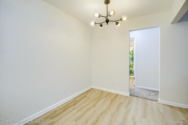 810 Plate St Unit 103, Rochester, MI 48307 - unfurnished room featuring a chandelier, wood finished floors, and baseboards
