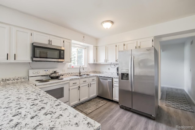 4851 Shoreline Blvd, Waterford, MI 48329 - kitchen with appliances with stainless steel finishes, a sink, light wood-style flooring, and white cabinets