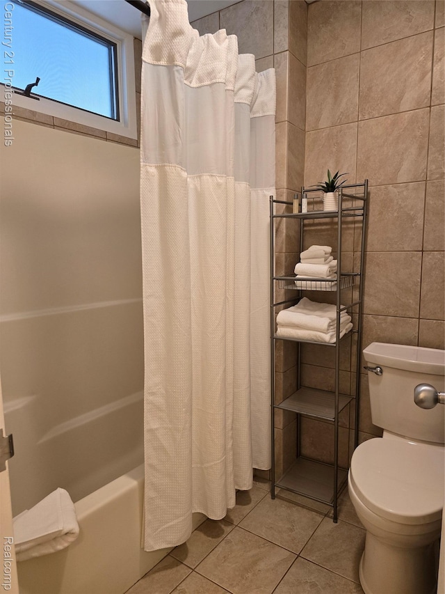 5714 N Creeks Xing, Williamsburg, MI 49690 - bathroom with tile patterned floors, tile walls, shower / bathtub combination with curtain, and toilet