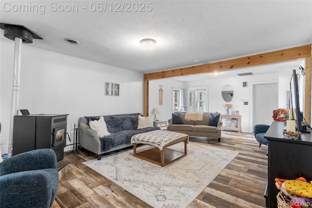 335 Main St, Morrice, MI 48857 - living area featuring wood finished floors, a wood stove, and a textured ceiling