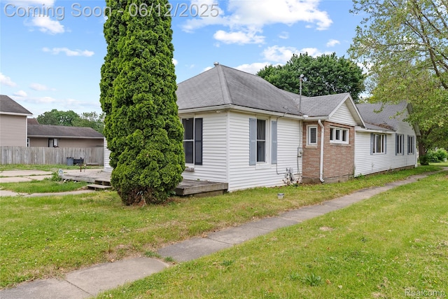 335 Main St, Morrice, MI 48857 - view of home's exterior featuring a wooden deck, a shingled roof, and brick siding