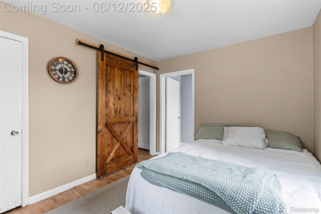 335 Main St, Morrice, MI 48857 - bedroom with a barn door, wood finished floors, and baseboards