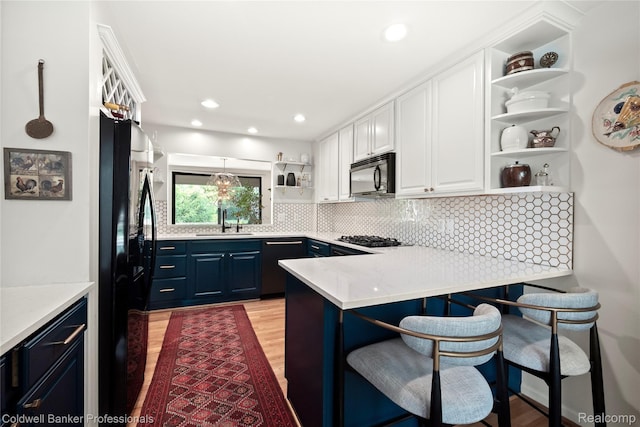 916 Tartan Trl, Bloomfield Hills, MI 48304 - kitchen featuring open shelves, black appliances, a sink, light wood-type flooring, and white cabinetry