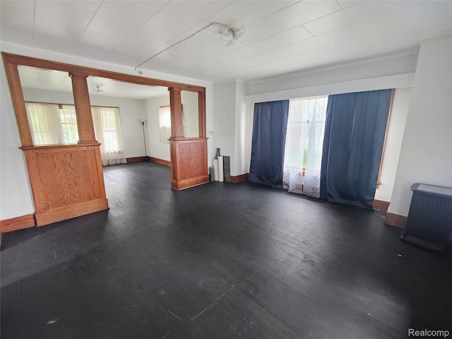 1505 Downey St, Flint, MI 48503 - unfurnished living room featuring baseboards, dark wood-style flooring, and decorative columns