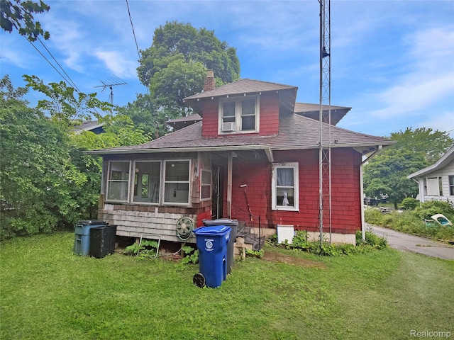 1505 Downey St, Flint, MI 48503 - bungalow-style home featuring a shingled roof, a chimney, a front yard, and a sunroom