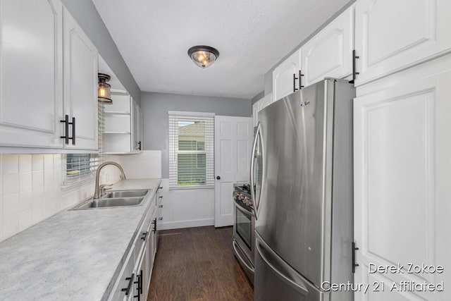 4246 Flamingo Ave SW, Wyoming, MI 49509 - kitchen featuring stainless steel appliances, a sink, dark wood-type flooring, white cabinetry, and decorative backsplash