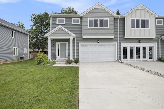 1047 Rebecca St, Marshall, MI 49068 - view of front facade with driveway, a front lawn, an attached garage, central AC, and board and batten siding