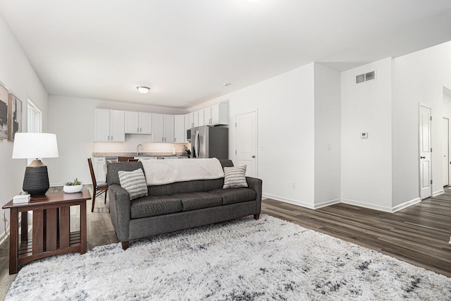 1047 Rebecca St, Marshall, MI 49068 - living room featuring dark wood-style floors and baseboards