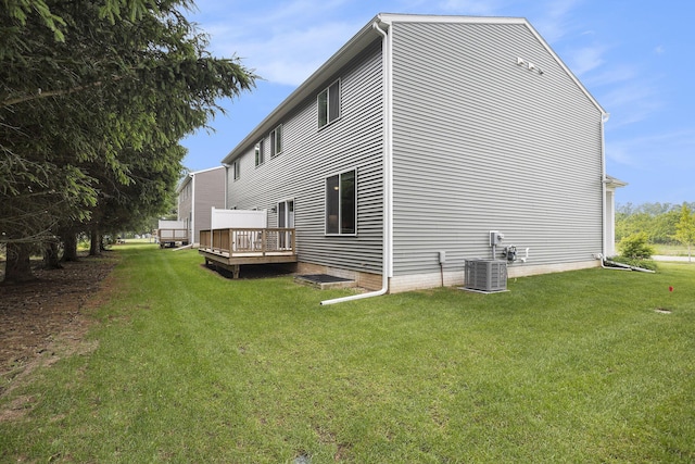 1047 Rebecca St, Marshall, MI 49068 - view of home's exterior featuring a wooden deck, a lawn, and central air condition unit