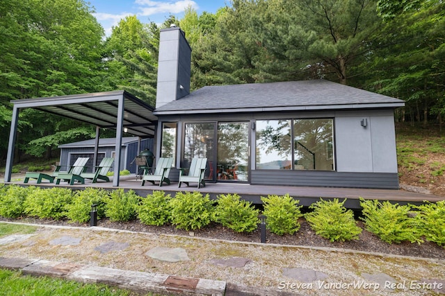 5185 W Nurnberg Rd, Michigan, MI 49411 - rear view of property featuring a wooden deck and a chimney