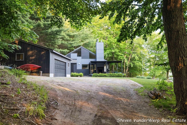5185 W Nurnberg Rd, Michigan, MI 49411 - view of front of property with a chimney, dirt driveway, and a detached garage
