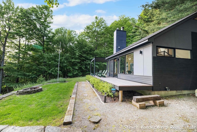 5185 W Nurnberg Rd, Michigan, MI 49411 - view of grassy yard with a fire pit and a wooden deck
