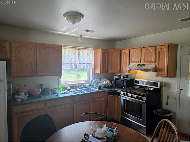 29827 Oakwood St, Inkster, MI 48141 - kitchen featuring stainless steel gas stove, under cabinet range hood, black microwave, a sink, and freestanding refrigerator