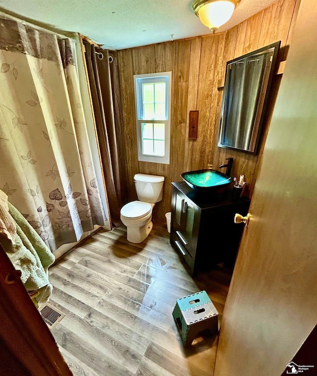 4340 Foothill Dr, Barton City, MI 48705 - bathroom featuring toilet, vanity, wood finished floors, and wood walls