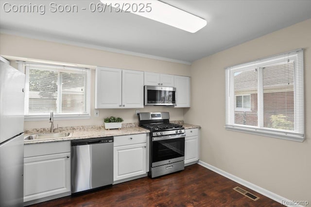 9243 Cornell St, Plymouth, MI 48180 - kitchen with appliances with stainless steel finishes, white cabinets, dark wood-style floors, and light stone counters