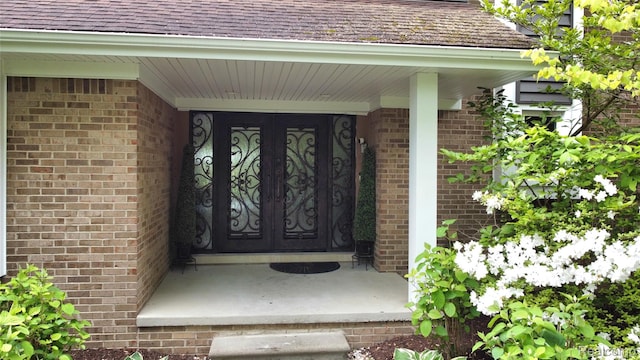 5084 Champlain Cir W, Bloomfield, MI 48323 - property entrance featuring brick siding, a shingled roof, and covered porch