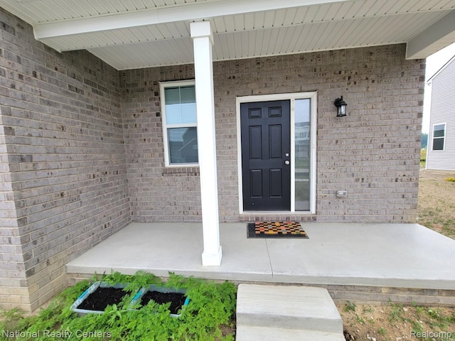 51485 Maple Leaf Dr, Macomb, MI 48042 - doorway to property with brick siding and a porch