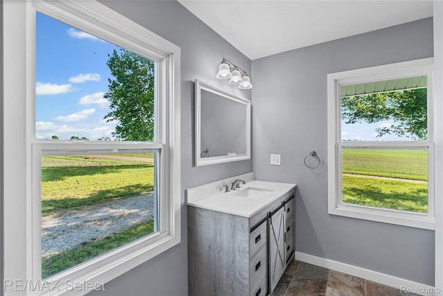 4470 N Lake Rd, Columbiaville, MI 48421 - bathroom with vanity, plenty of natural light, and stone tile flooring