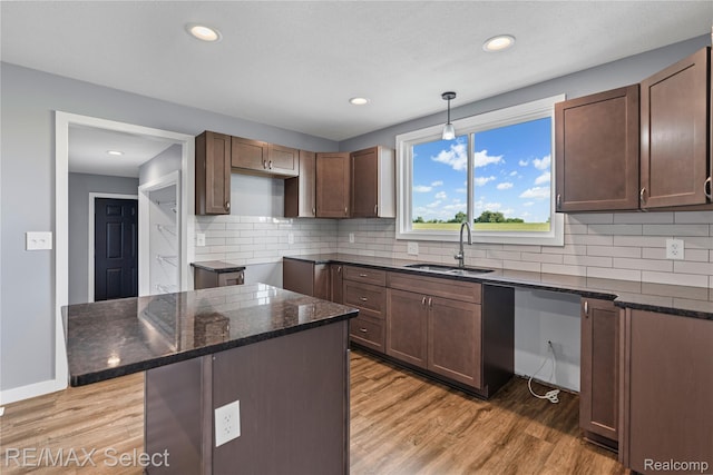 4470 N Lake Rd, Columbiaville, MI 48421 - kitchen with dark stone counters, light wood finished floors, backsplash, recessed lighting, and hanging light fixtures