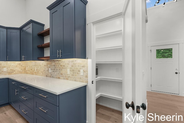 8060 Hunters Xing, Kalamazoo, MI 49009 - kitchen with open shelves, blue cabinets, light wood finished floors, backsplash, and light countertops